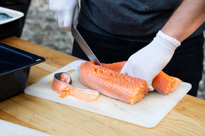 Midsection of man preparing food on cutting board