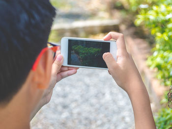 Midsection of man photographing with mobile phone