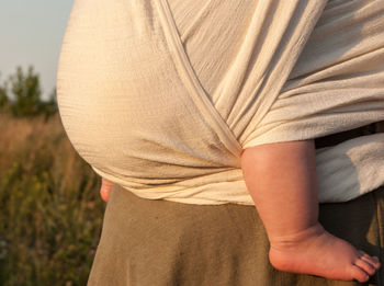 Close-up of mother with baby carrying in fabric