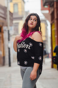 Portrait of a beautiful young woman standing in city