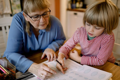 Grandmother assisting grandson in doing homework