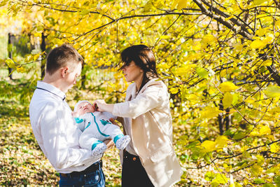 Young couple standing against plants