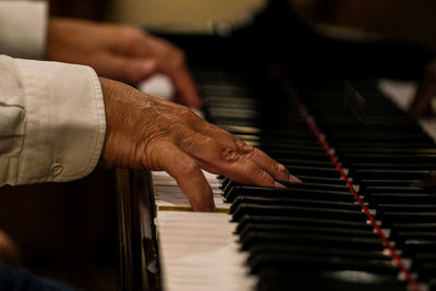 Cropped hands of man playing piano