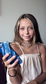 Portrait of smiling girl holding mobile phone