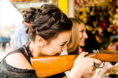 Happy woman target shooting with gun at oktoberfest