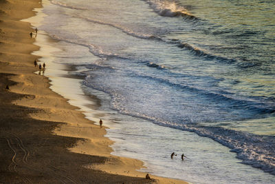 Aerial view of silhouette people at beach during sunset