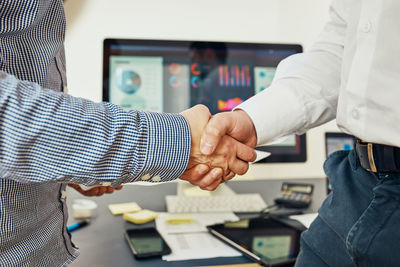 Handshake of business people. man and woman shaking hands in office. two people greeting at work