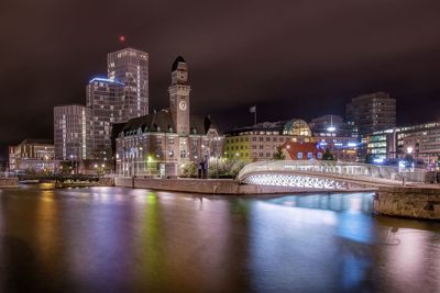 Illuminated buildings in city against sky