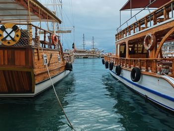 Sailboats moored on sea against sky