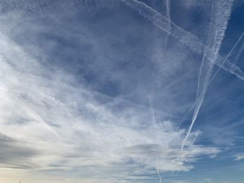 Low angle view of vapor trails against sky