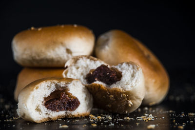 Close-up of sweet buns on table against black background