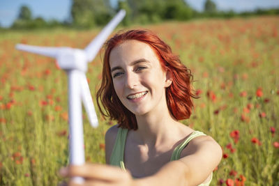 Portrait of young woman sitting on field