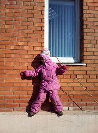 Girl standing against brick wall