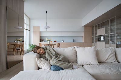 Woman sitting on bed at home