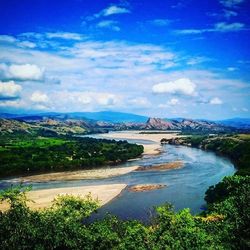 Scenic view of river against cloudy sky