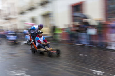 Blurred motion of people riding motorcycle on street