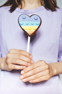 Midsection of woman holding thermometer