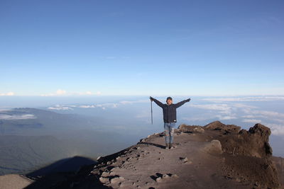 Full length of man standing on mountain against sky