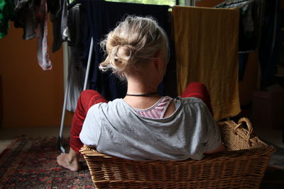 Woman sitting in basket at home