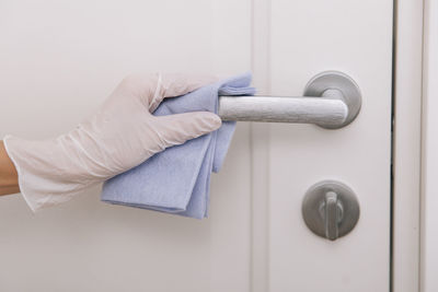 Cropped hand of person holding door handle