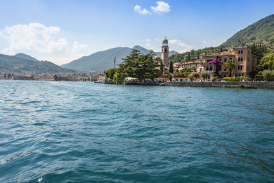 Scenic view of sea by buildings against sky