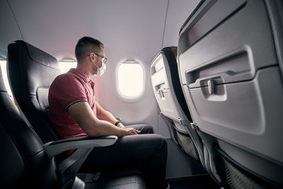 Rear view of man sitting in airplane