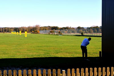 Man standing on field against clear sky