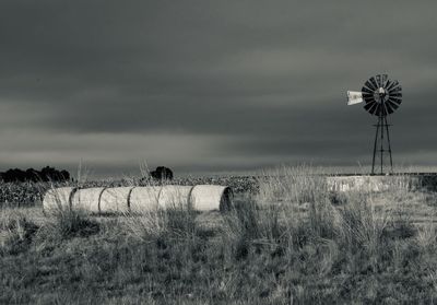 Wind turbines on field against sky