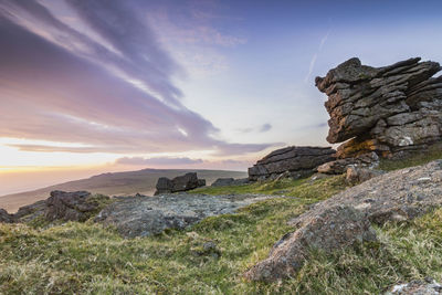 Rock formation on land against sky during sunset