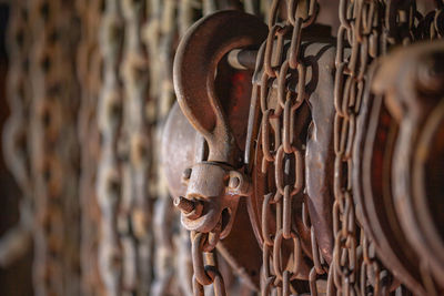 Close-up of rusty chain hanging on metal gate