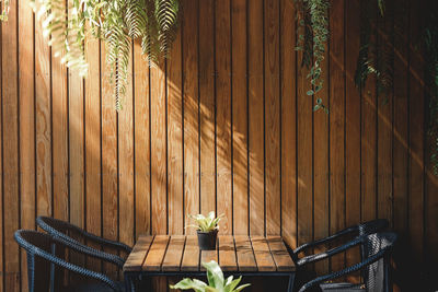 Empty chairs with wooden table arranged by wall