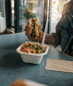 Person holding food on table in restaurant