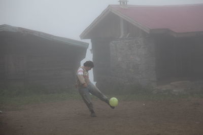 Full length of woman playing soccer ball