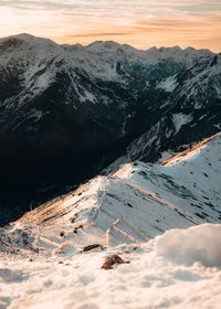 Scenic view of snowcapped mountains against sky during sunset