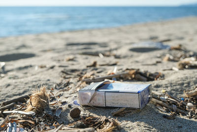 Dirty cigarette pack trash discarded on sea coast ecosystem,environmental pollution issues