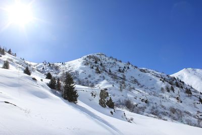 Low angle view of snowcapped mountain against blue sky