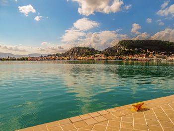 Swimming pool by lake against sky