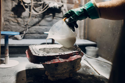 Cropped hand of person pouring water