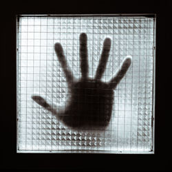 Shadow of hand on glass