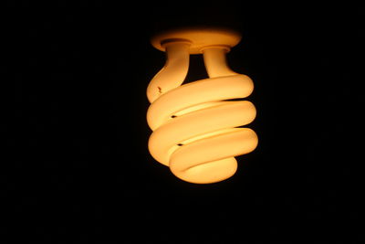 Close-up of light bulb over black background