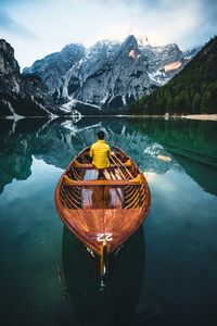 Scenic view of lake by snowcapped mountains against sky