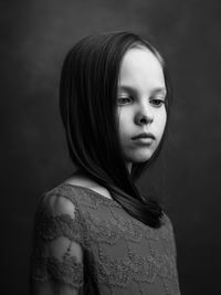 Girl standing against black background