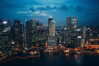 Aerial view of illuminated buildings in city against sky at night