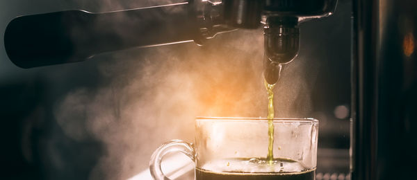 Barista add coffee bean roaster into coffee machine at coffee shop