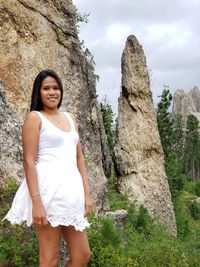 Portrait of smiling young woman standing on rock