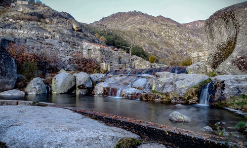 Scenic view of river by mountains against sky