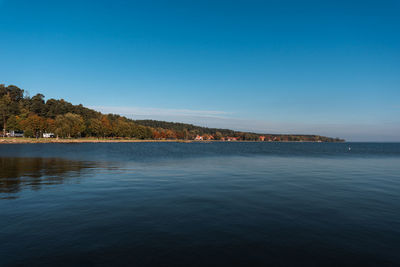 Scenic view of curonian lagoon against clear blue sky near juodkrante town