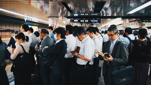 Group of people waiting at railroad station platform