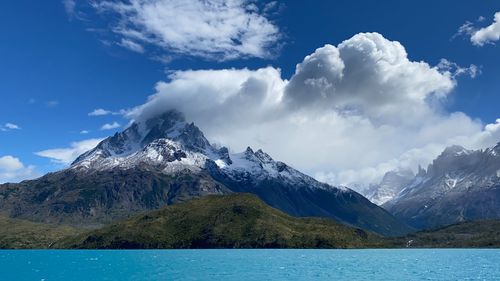 Scenic view of snowcapped mountains against sky and clouds