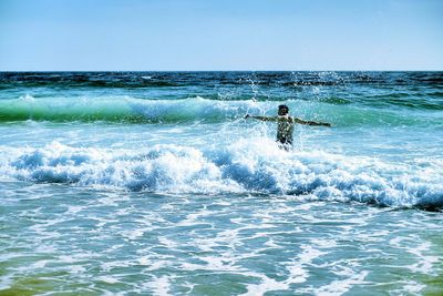 Man surfing in sea against sky